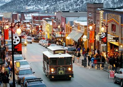 Snow covered trolley drives on crowded Park City Street