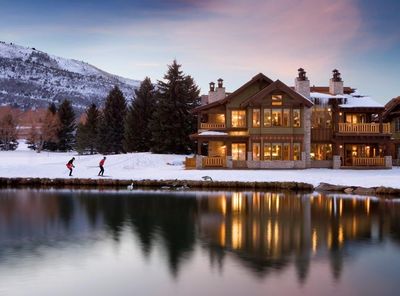 a snow covered hotel next to a lake